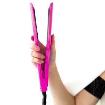 woman-holding-hair-straightener-that-has-word-hair-it